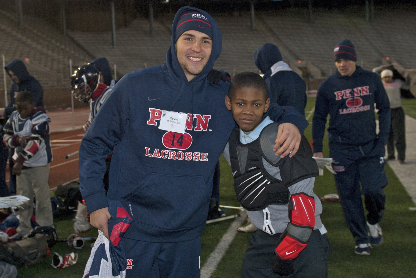 Penn Lacrosse player with younger player