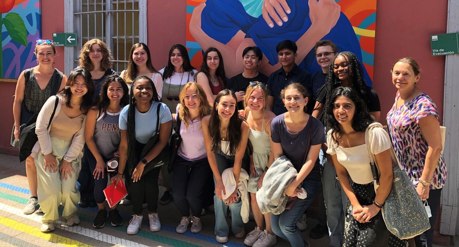 mural with students posing in front