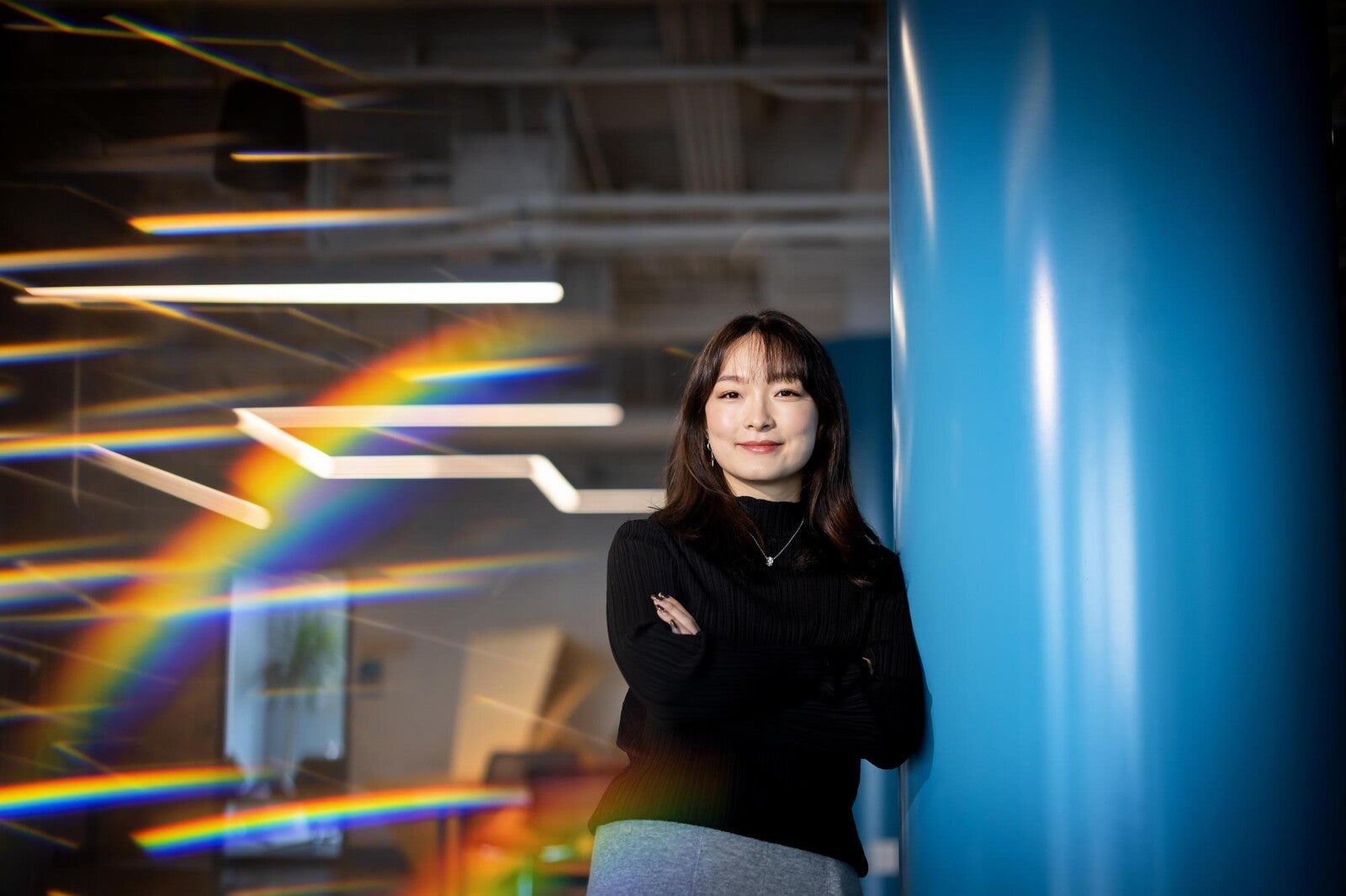 portrait of eileen feng, leaning on blue pillar