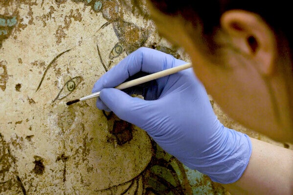 restorationist working on buddhist mural