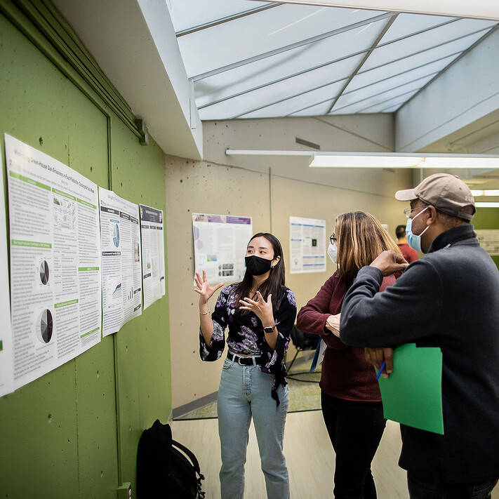 A student presents their work during a poster session in the 'Humans and the Earth System: How it Works, How We Got Here, and How to Save Our Planet' class.